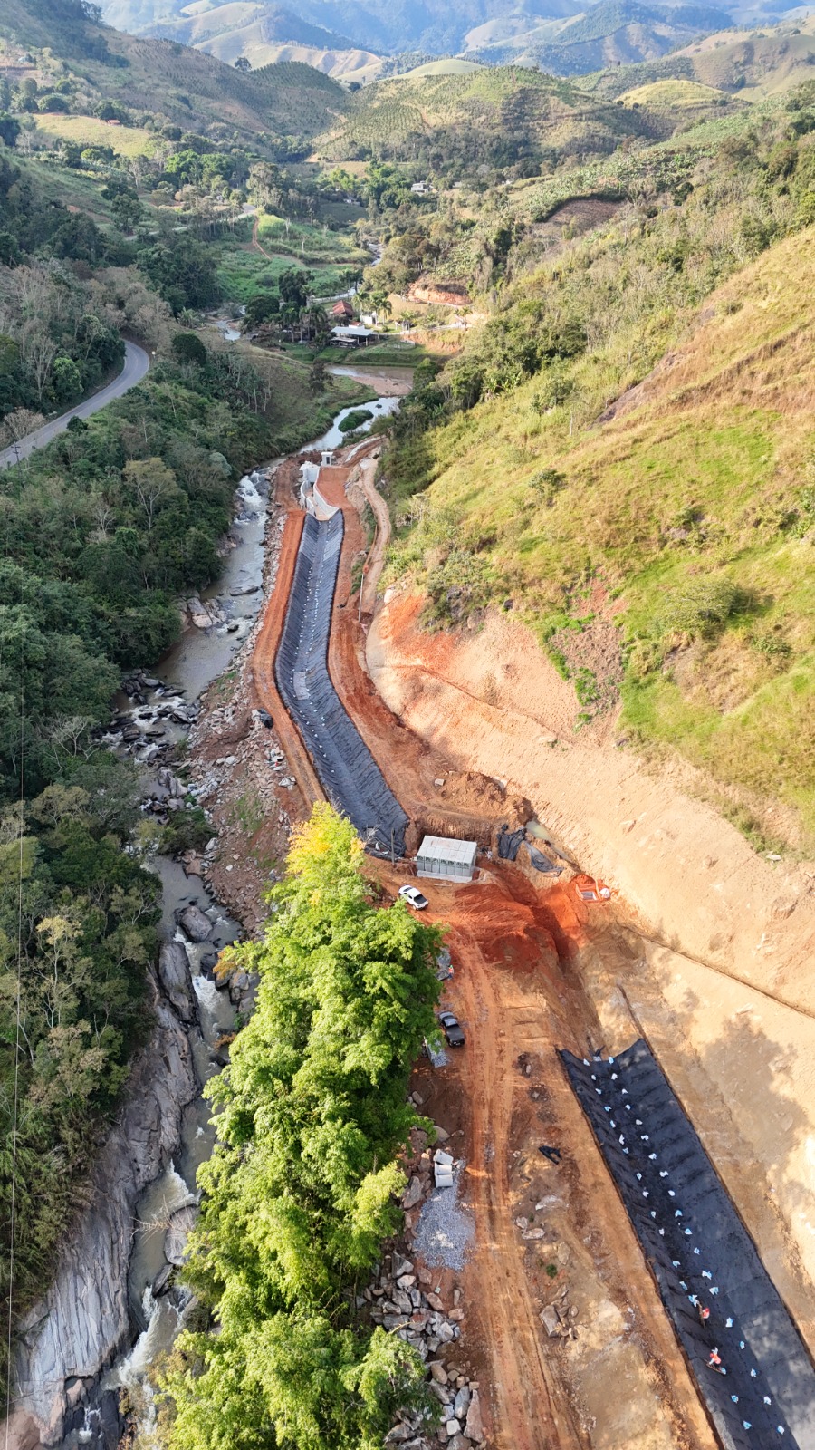 Canal de adução em construção revestido com geomembrana PEAD — SPE Paquequer, Sumidouro/RJ